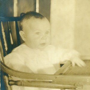 Bébé dans une chaise haute attendant patiemment de la nourriture plateau en bois RPPC Photo réelle carte postale photographie vintage
