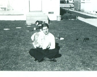 1940s nuevo papá hombre sosteniendo bebé recién nacido fuera de hierba cruz piernas traje 40s Vintage fotografía negro blanco foto