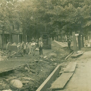 Cartão Postal De Pavimentação De Trabalho Rodoviário Através De Carrinhos De Cidade Homens Em Pé 1900s RPPC Foto Real