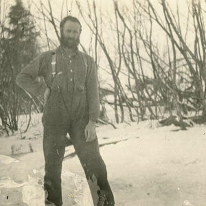 Uomo d'epoca dell'Alaska in piedi fuori dalla neve inverno barba antica cartolina fotografica RPPC autentica Alaskan AZO