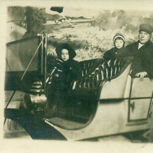 Little Girl Driving Car Dad in Backseat Winter Studio Portrait 1920s RPPC Real Photo Postcard Photograph Black White Photo