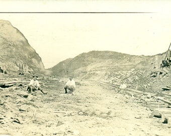 Panamakanal-Bauarbeiter-Männer, die Felsen-Eisenbahnschienen antike RPPC reale Foto-Postkarte sitzen