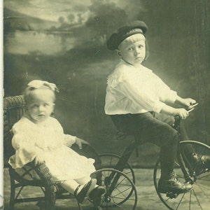 Antique CPPR garçon sur Tricycle bébé soeur fille en osier chaise sépia photo carte postale Photo