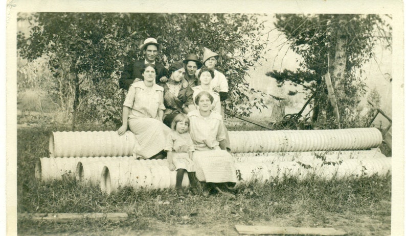 Fun Family Sitting on Culvert Drain Pipes Man Wearing Funny Hat in Back 1910s RPPC Postcard Antique Photo Photograph