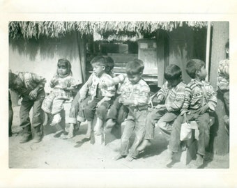 South American Indigenous Kids Sitting on Bench Eating Lunch Barefoot Traditional Clothes Vintage Black White Photo Photograph