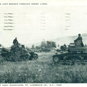 May include: Vintage black and white postcard depicting military tanks in a field. The text at the top reads, "THE TANKS HAVE JUST BROKEN THROUGH ENEMY LINES." The bottom of the postcard reads, "SOUVENIR FIRST ARMY MANEUVERS, ST. LAWRENCE CO., N.Y., 1940."