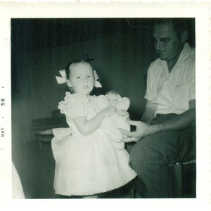 1958 Menina Segurando Uma Boneca Pai Ajudando Um Vestido Bonito Foto Preto Branco