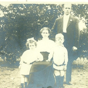 Família sob árvore frutífera menino menina pais pomar 1900 antigo RPPC foto real cartão postal foto preto e branco