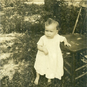 Barfuß Baby Mädchen stehend draußen stehend auf Stuhl umspielte Haare 1910er RPPC Echt Foto Postkarte Fotografie