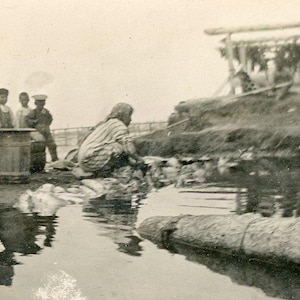 Antico Port Heiden Bering Sea Alaska Nativo Eschimese Donna Lavare in Stagno Ragazzi Guardare Macchina Fotografica Pesce Essiccatoio Foto Fotografia Vintage