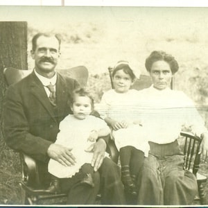 Entschlossene Stern Mutter sitzend Draußen Familie Glücklicher Ehemann Mädchen 1910er Jahre RPPC Echt Foto Postkarte