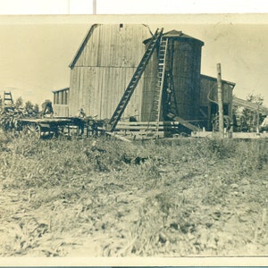 Ouvriers agricoles des années 1910 avec récolte sur des échelles hautes de chariot au silo Antique RPPC Real Photo Carte postale