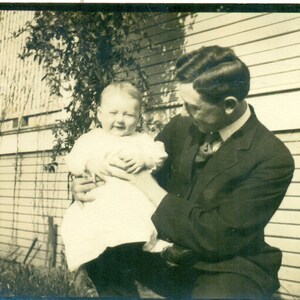 家の外で赤ちゃんを抱っこして見つめる誇らしげな父親 RPPC 実写ポストカード写真 白黒写真
