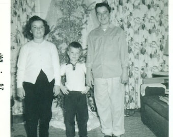 1950s Christmas Brothers Sister Standing in Front of Tree Mid Century Holiday Vintage Black White Photo Photograph