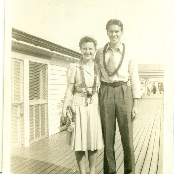 Hawaii Honeymoon Young Couple Wearing Leis Standing on Wood Boardwalk 1940s Vintage Black White Photo Photograph