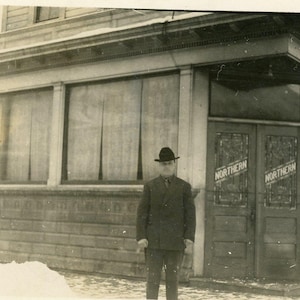 Northern Commercial CO Store Building portes homme debout à l'extérieur de l'hiver antique carte postale photo réelle RPPC Alaska