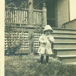 1920s Toddler Baby Girl Standing Outside Sun Hat House Porch Sepia Vintage Photograph Black White Photo