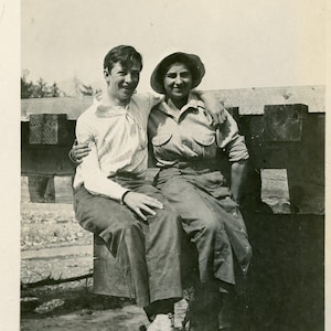 Vintage des années 1920 Alaska homme femme assis sur un quai poste océan péninsule de Kenai RPPC carte postale photo réelle