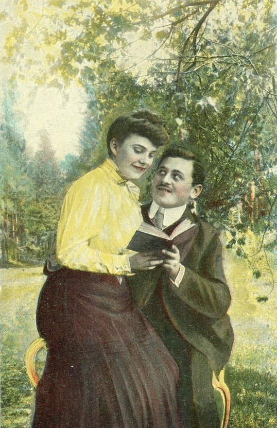1900s Man in Love Looking at Woman Reading Book Sitting in Lap