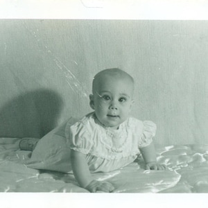 Cross Eyed Baby Girl Laying Holding Herself Up on Bed Tummy Time 1950s 50s Vintage Photograph Black White Photo