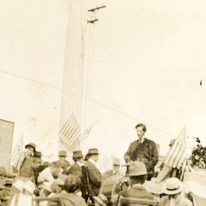 Discurso político vintage de Alaska, hombre en el escenario, banderas de EE. UU., plaza del pueblo, postal antigua de foto real de RPPC, AZO Alaskan