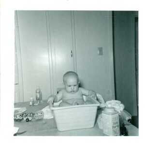 1963 Unsure Baby Getting Bath in Basin on Kitchen Table Photo Black White Photograph