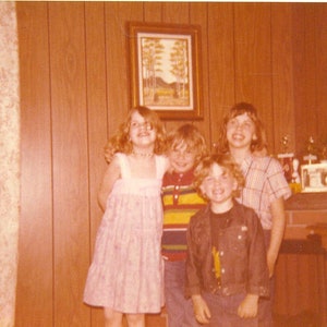 1979 Kids Standing in Wood Panel Living Room Trophies on Mantle Brothers Sisters 70s Vintage Photograph Color Photo