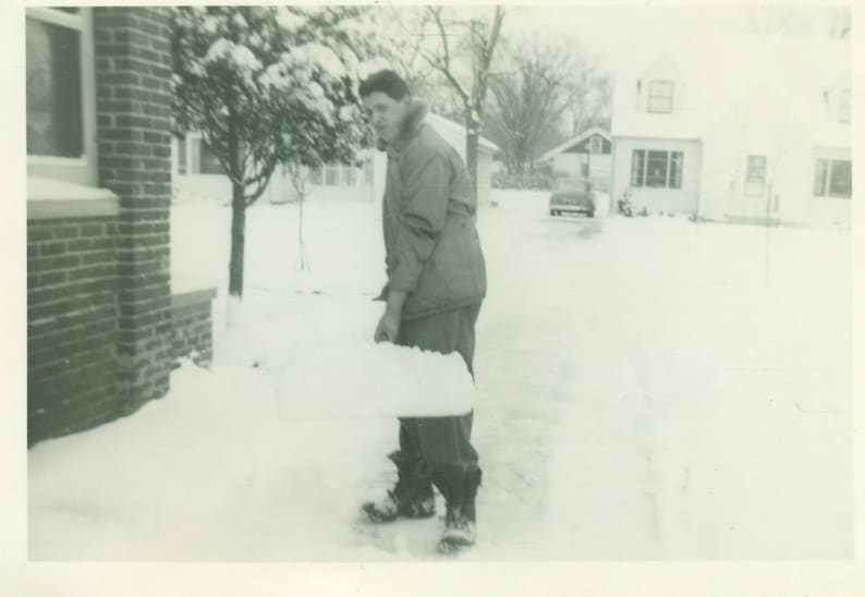 Winter Stinks Unhappy Man Shoveling Snow on Shovel Driveway Frown 1940s Vintage Black White Photo Photograph image 1