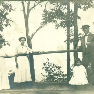 1910s Family Holding Onto A Wood Pole Rail Man Women Girl Outside RPPC Real Photo Postcard Antique Photograph