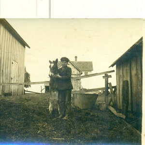 納屋と農家の間にいる子馬を抱く少年 1910 年代 RPPC 実写ポストカード写真