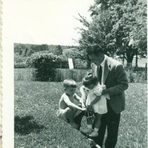 jaren 1950 jongen meisje spelen op paard Zie zag wip met papa achtertuin leuk speelgoed 50s Vintage foto zwart-wit foto