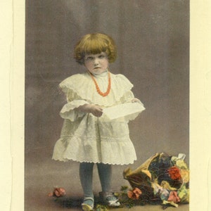 Bambina che legge la lettera cesto di fiori colore antico RPPC reale foto cartolina di auguri