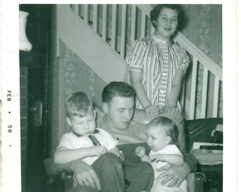 1958 Dad With Boy and Baby Sitting in Lap Mom Standing Behind Living Room 1950s Black White Photo Photograph Vintage