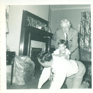 1953 Boy Climbing on Dads Back For A Ride Grandpa Help 50s Photo Black White Photograph
