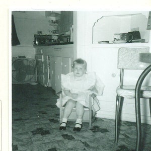 Onbenullige tijd klein meisje zittend op kind grootte stoel mooie jurk jaren ' 50 vintage foto zwart wit foto