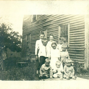 9 Enfants Grande Ferme Famille Garçons Filles Pieds Nus Bébés à l’extérieur de la maison RPPC Real Photo Carte postale Photographie