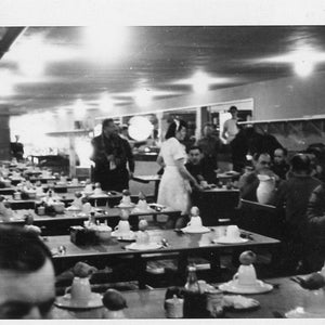 Navio de passageiros dos anos 1950, refeitório, restaurante, garçonete, em pé, conversando com a mesa de homens, foto vintage, fotografia em preto e branco