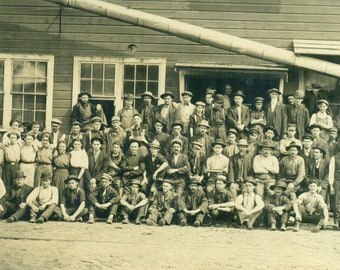 Ouvriers d'usine, beaucoup d'hommes et quelques femmes, photo de groupe à l'extérieur du bâtiment des années 1900, carte postale avec photo réelle du RPPC