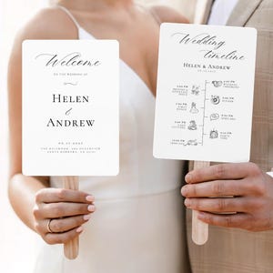 Könnte beinhalten: Zwei weiße Hochzeitsfächer mit Holzgriffen. Auf einem Fächer steht "Welcome" und die Namen "Helen & Andrew". Der andere Fächer zeigt einen Hochzeitszeitplan mit den Namen "Helen & Andrew" und dem Datum.