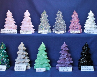 May include: Ten glass Christmas tree ornaments in various colors, including pink, white, clear, teal, grey, green, purple, and black. The ornaments are arranged in two rows on a blue surface. Each ornament has a label with its color and name.