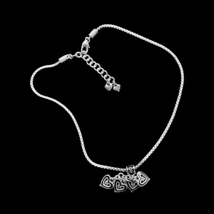 Może przedstawiać: Srebrny naszyjnik z łańcuszkiem i srebrnym zawieszką w kształcie pięciu splecionych serc. Naszyjnik zapinany jest na karabińczyk.
