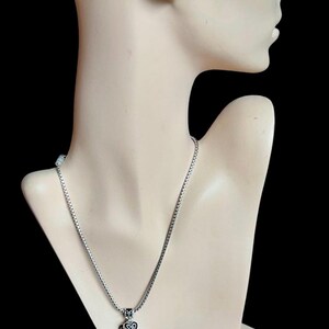 Może przedstawiać: Srebrny zestaw naszyjnika i bransoletki z zawieszką w kształcie kilku czarnych i srebrnych serc.