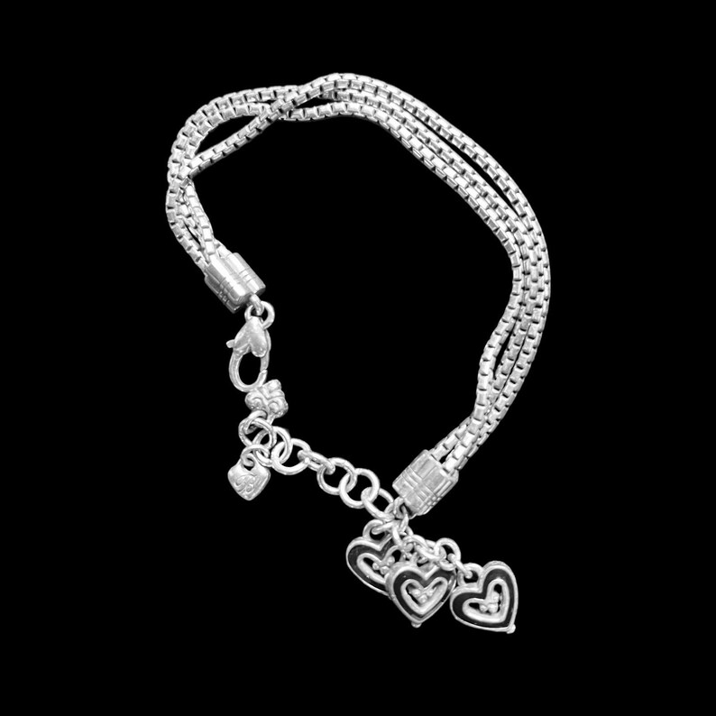Może przedstawiać: Srebrna bransoletka z łańcuszkiem i wieloma zawieszkami w kształcie serca.