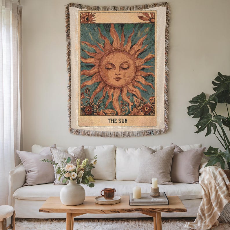 Boho woven blanket showing a tarot card in vintage style, representing "The Sun" card. Cosy throw blanket in 100% cotton, with a sunny and spiritual design in warm and natural colors. Perfect for cozy evenings at home or outdoor, available in three sizes. Must have for anyone who wants to add warm and positive decor to its home. Great gift for yourself or others.