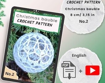 May include: A crocheted Christmas bauble pattern displayed on a tablet screen. The bauble is white and spherical, with a textured, openwork design. The screen also shows the text "Christmas bauble CROCHET PATTERN" and "No.2".