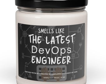 Peut inclure: Un bocal de bougie blanc avec un couvercle noir et une étiquette qui indique "Smells Like The Latest DevOps Engineer" avec un graphique d'icônes informatiques. L'étiquette indique également "Infused with automated workflows and a hint of tame. 100% Soy Wax | 9 oz."