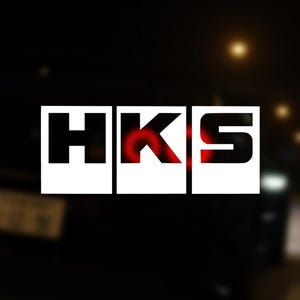 Puede incluir: Una pegatina de logotipo HKS blanca en un coche negro. El logotipo está en tres cuadrados separados, con las letras H, K y S en negro.