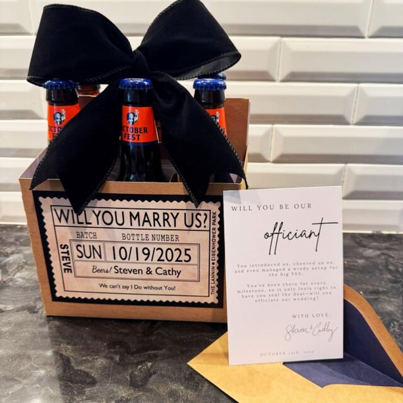 May include: A gift box containing four beer bottles, a black bow, and a card. The box label says "Will You Marry Us?" with the date of October 19, 2025. The card asks "Will You Be Our Officiant?"
