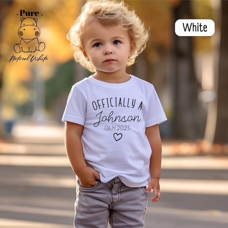 a little girl in a white shirt is standing on a skateboard