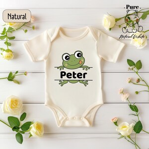 a white bodysuit with a green frog on it